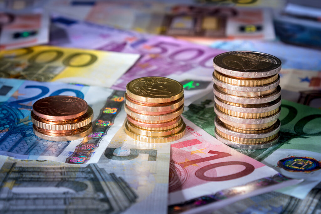 Euro coins and notes stacked on a table.