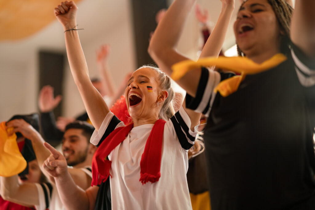 Enthusiastic football fans cheer in the stadium.