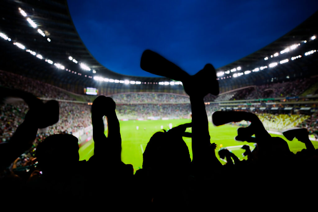 Fußballfans jubeln im Stadion.