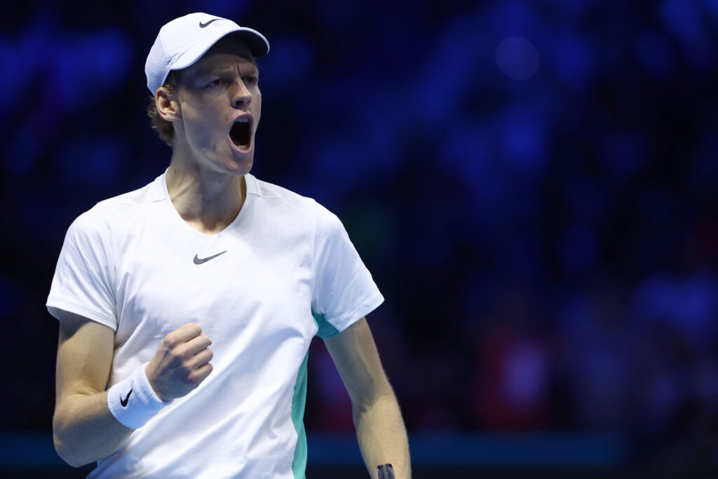 Tennis player cheers on the court in a white shirt