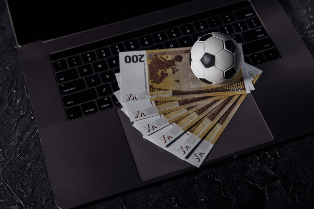 Laptop with banknotes and football