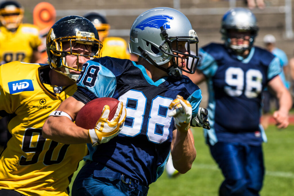 American football players run with ball