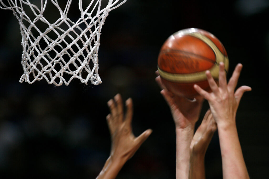 Basketball game, basket and hands in the foreground